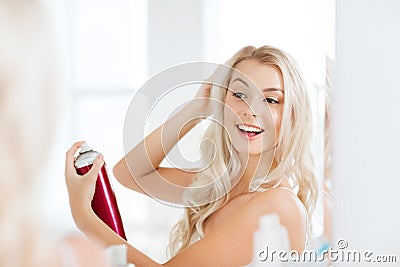 Woman with hairspray styling her hair at bathroom Stock Photo