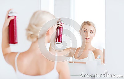 Woman with hairspray styling her hair at bathroom Stock Photo