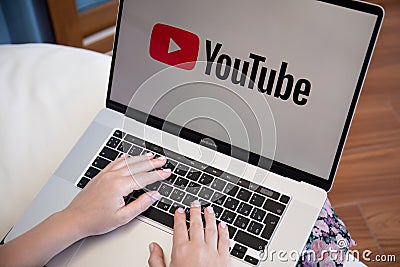 Woman hand Apple Macbook with App YouTube the screen laptop Editorial Stock Photo