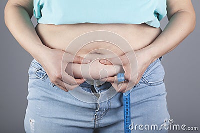 Woman hand belly fats Stock Photo