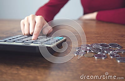 Woman hand calculator and coins Stock Photo