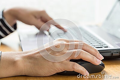 Woman hand click mouse and laptop Stock Photo