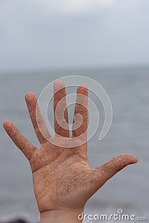 Woman hand covered in sand on the beach Stock Photo