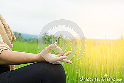 Woman hand doing yoga and meditation over nature green field Stock Photo