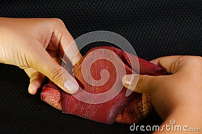 Woman hand folding banana blossom. Stock Photo