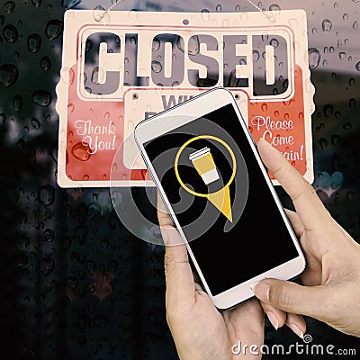 Woman hand hold and touch screen smart phone, closed sign board Stock Photo