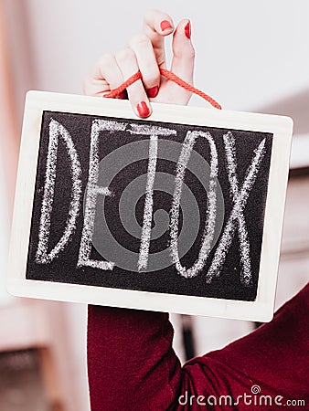 Woman hand holding board with detox sign Stock Photo