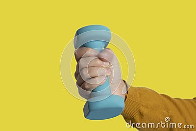 Woman hand holding dumbbell on yellow background. Equipment for workout. Fitness and activity.Power ,success, sport and healthy Stock Photo