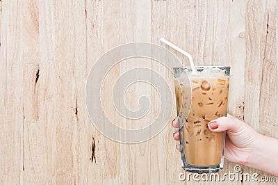 woman hand holding the glass iced coffee on wooden background Stock Photo