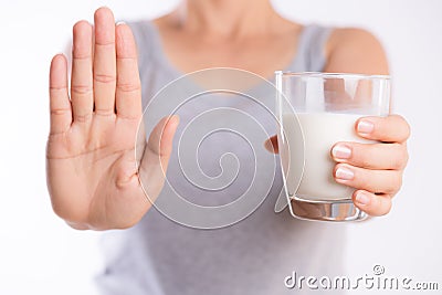 Woman hand holding glass of milk having bad stomach ache because of Lactose intolerance and another hand shows stop sign. health Stock Photo