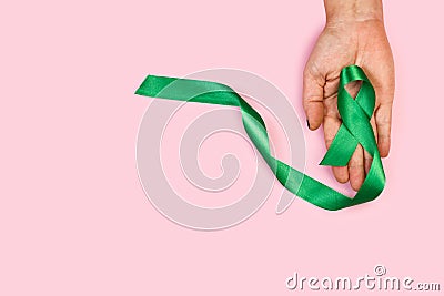 Woman hand holding a green ribbon Stock Photo