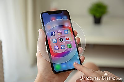 Woman hand holding iPhone X with social networking Messenger Editorial Stock Photo