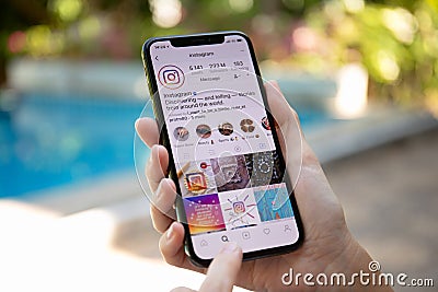 Woman hand holding iPhone X with social networking service Instagram Editorial Stock Photo