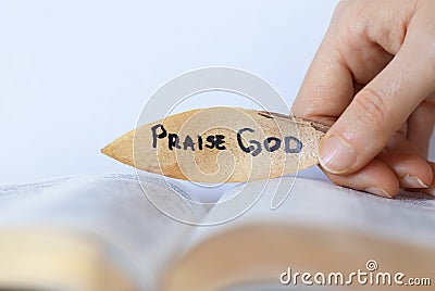 Woman hand holding leaf with a written message to praise God our Father and our Lord Jesus Christ Stock Photo
