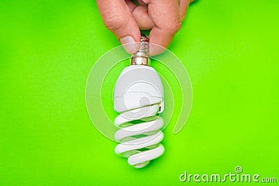 Woman hand holding light bulb on green background Stock Photo