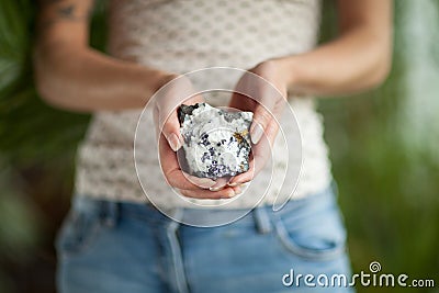 Woman hand holding little crystal mineral rock, sensual studio shot with soft light Stock Photo