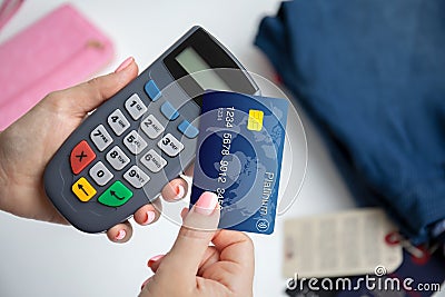 Woman hand holding plastic card and pay pass online terminal Stock Photo