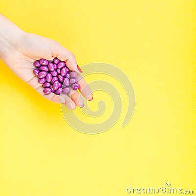 Woman hand holding purple pills handful Stock Photo