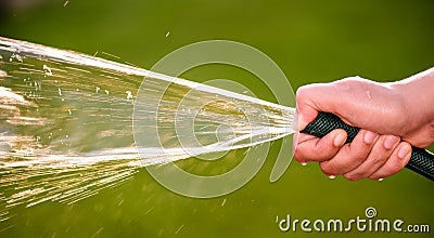 Woman hand holding rubber water hose and using finger Stock Photo