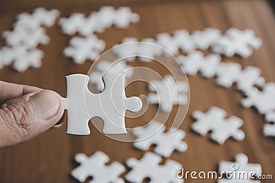 The woman hand holds a jigsaw, solutions and strategy Concep Stock Photo