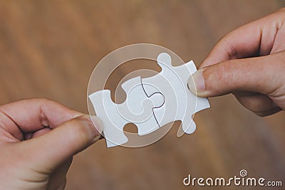The woman hand holds a jigsaw, solutions and strategy Concep Stock Photo