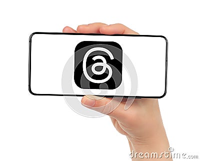 Woman hand holds smart phone with Threads mobile service icon on white background. Meta Officially Launches Threads which widely Editorial Stock Photo