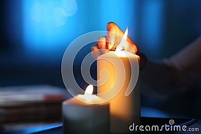 Woman hand lighting candle in the night at home Stock Photo