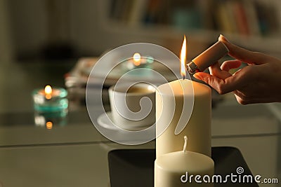 Woman hand lighting candles with lighter at night Stock Photo