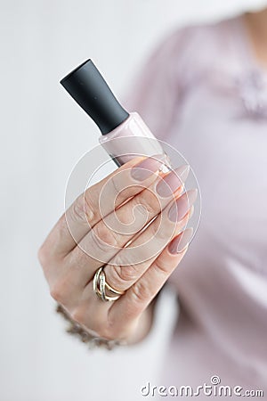 Woman hand with manicure and pink bottle with nail polish Stock Photo