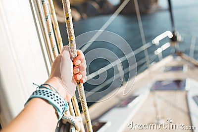 Woman hand on luxury yacht tackle. Stock Photo