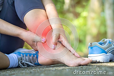 Woman hand massaging her leg pain suffering from twisted ankle broken from exercise Stock Photo