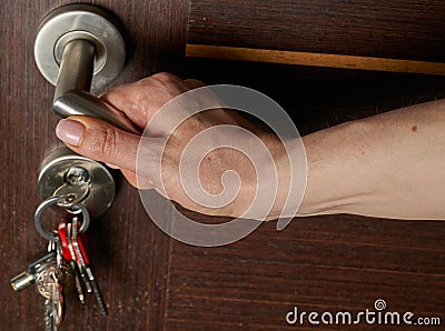 Woman hand open a door. Keys hanging in lock Stock Photo