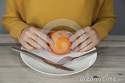 Woman hand orange on plate Stock Photo