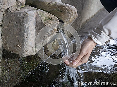 Woman hand pouring Water on nature spring Stock Photo