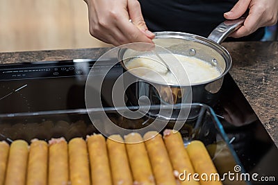 A woman hand prepares at home in the kitchen Bechamel sauce for cannelloni. Domestic life. Lifestyle cooking photos Stock Photo