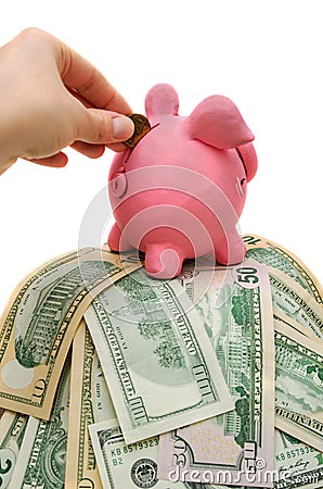 Woman hand putting coin in piggy bank with money Stock Photo