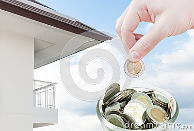 Woman hand putting a coin on ,saving ,Donation Investment ,Coins in hands money Savings and apartment Stock Photo