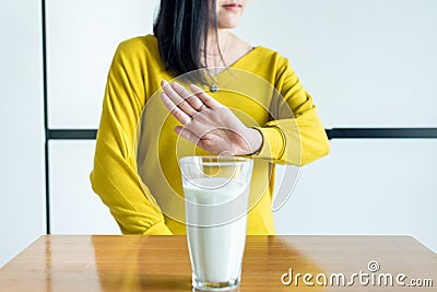 Woman hand refusing a glass of milk,Female having allergy milk,Lactose intolerance concept Stock Photo
