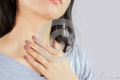 Woman hand self checking thyroid gland on her neck Stock Photo