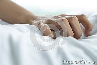 Woman hand with sex orgasm gesture pose acting on white bed, close up Stock Photo