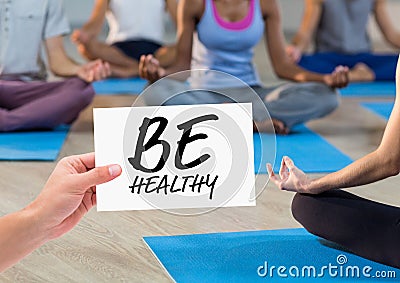 Woman hand showing be healthy text written on page Stock Photo