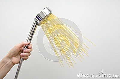 Woman Hand With Silver Shower and Pasta Spaghetti like Water Jet Stock Photo