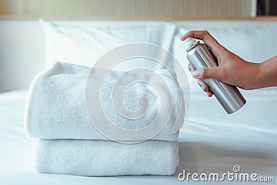 Woman Hand is Spraying Air Freshener to Towels in Bedroom, Unpleasant smell and Aromatherapy Concept Stock Photo