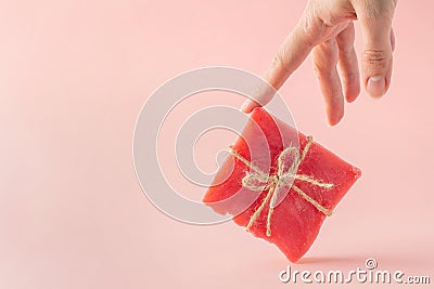 Woman hand supports a pink soap bar Stock Photo