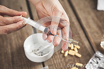 Woman hand syringe with drug and cigarettes Stock Photo