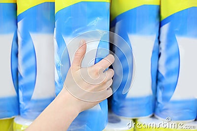Woman hand takes pack of toilet paper in shop Stock Photo