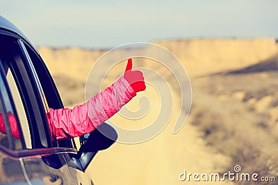 Woman hand with thumb up travel by car on road Stock Photo