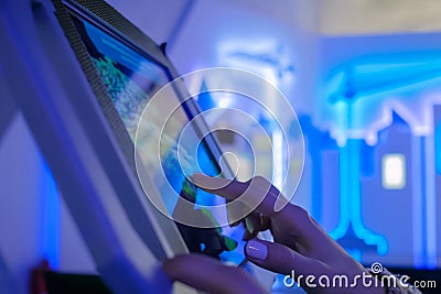 Woman hand using touchscreen display of floor standing tablet kiosk Stock Photo