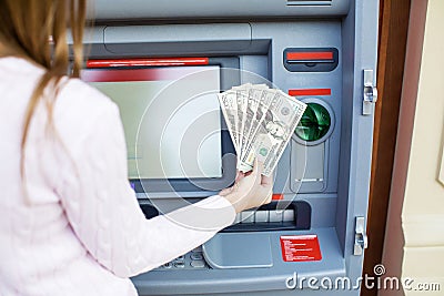 Woman hand withdrawing money from outdoor bank ATM Stock Photo