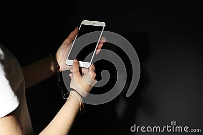 Woman in handcuffs using smartphone on black background, closeup. Solitude concept Stock Photo